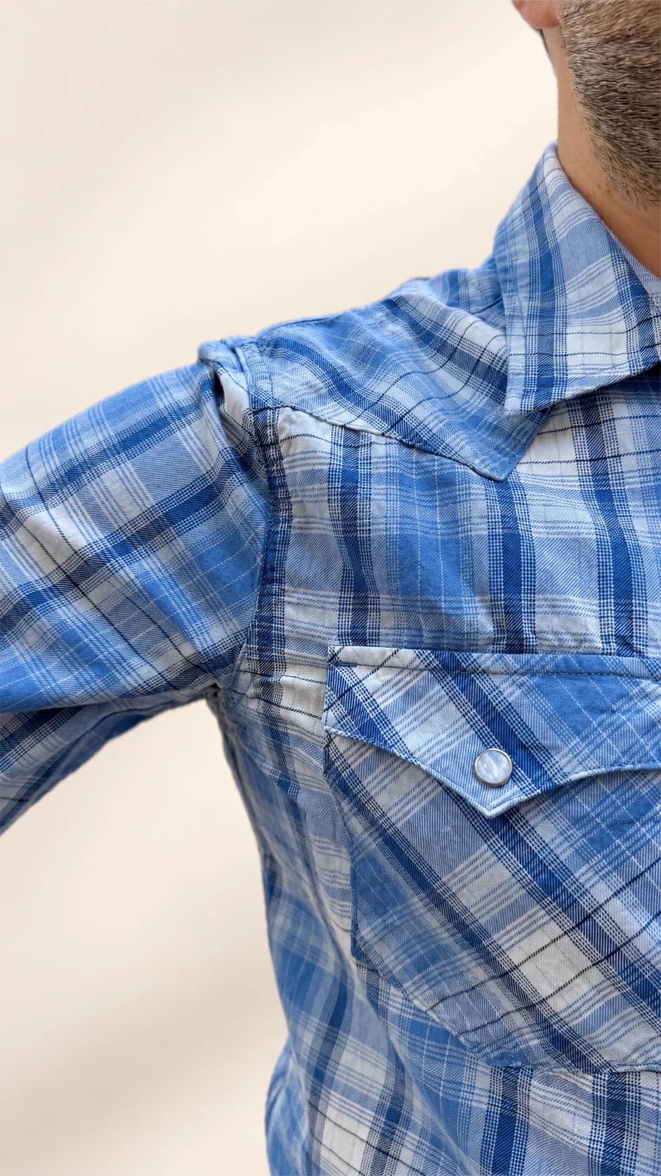 Underarm sweat pad beneath a blue plaid shirt