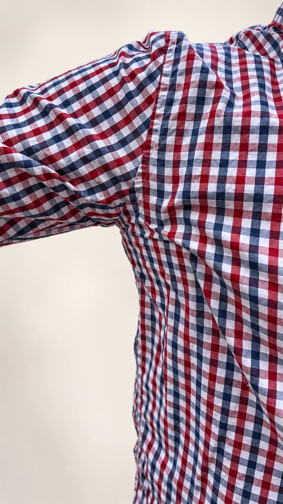 Underarm sweat pad beneath a red and navy gingham shirt