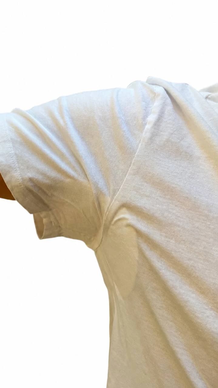 Pad outline visible through thin white T-shirt fabric in the underarm area